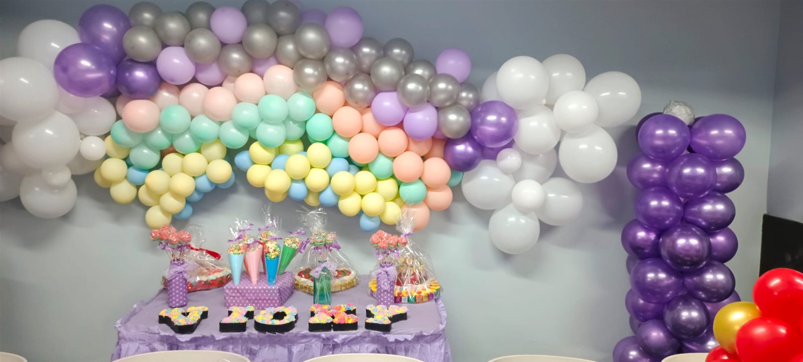 Decoración de cumpleaños con arco de globos pastel